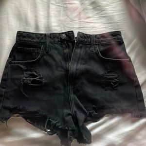 High waisted black booty shorts with cuts.